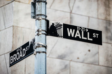 Straßenschild, das an einem rostigen Metallmast in der Nähe eines mehrstöckigen Gebäudes auf einer Stadtstraße vor einem unscharfen Hintergrund in New York, USA, befestigt ist - ADSF52034