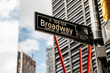 Low Winkel der Straße mit modernen Gebäuden und mit Straßenschild Broadway Canyon of Heroes auf Mast von Manhattan, New York in hellem Tageslicht gegen unscharfe Hochhauskonstruktionen und bewölkten blauen Himmel - ADSF52036