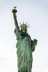 Von unten der gealterten Stein berühmte Freiheitsstatue auf Sockel in New York Stadt gegen wolkenlosen trüben Himmel gelegen - ADSF52039