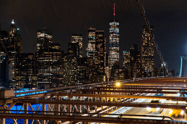 Nighttime cityscape featuring the bright lights of Manhattan skyscrapers from Brooklyn bridge viewpoint. - ADSF52043