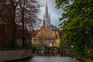 Historische Architektur in Brügge mit dem Kirchturm der Liebfrauenkirche über einer Kanalbrücke, Belgien - ADSF52373