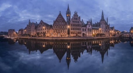 Die historischen Gebäude von Gent spiegeln sich in der Dämmerung im ruhigen Wasser und zeigen den mittelalterlichen Charme der Stadt - ADSF52396