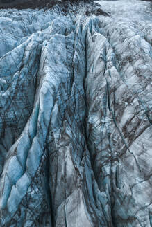 Top view close up of textured dry surface of massive Vatnajokull glacier with cracks in Iceland on winter day - ADSF52530