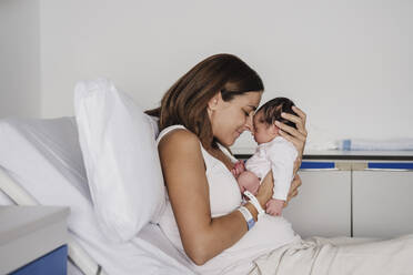 Loving mother embracing baby daughter in hospital - EBBF08277