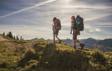 Young couple hiking on mountain trail in Tannheimer Tal, Tyrol, Austria - UUF30983