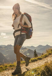 Young woman walking on mountain trail in Tannheimer Tal, Tyrol, Austria - UUF30984