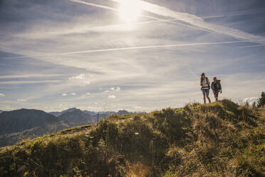 Mann und Frau wandern auf einem Bergpfad im Tannheimer Tal, Tirol, Österreich - UUF30988
