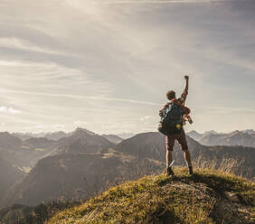 Junger Rucksacktourist auf einem Berggipfel im Tannheimer Tal, Tirol, Österreich - UUF30991