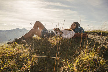 Young woman resting on mountain in Tannheimer Tal, Tyrol, Austria - UUF30994