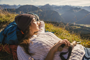 Backpacker resting on mountain in Tannheimer Tal, Tyrol, Austria - UUF30995