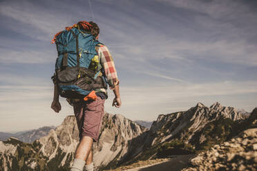 Rucksacktourist beim Wandern auf einem Berg im Tannheimer Tal, Tirol, Österreich - UUF30996