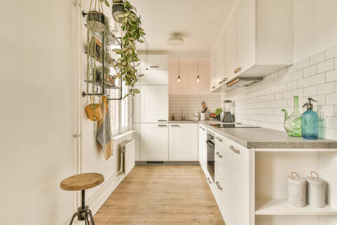 Interior of modern kitchen with modern appliances and white cabinets in contemporary light apartment - ADSF52560