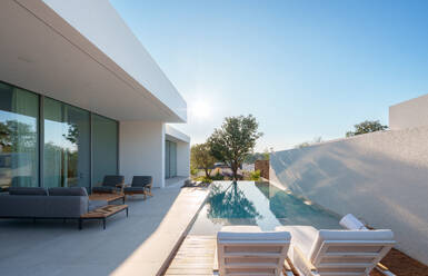 Modernes, minimalistisches, nachhaltiges Haus mit einem klaren, blauen Pool mit glatten, weißen Wänden und einem ruhigen Himmel im Hintergrund - ADSF52578