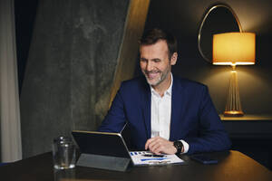 Lächelnder Geschäftsmann mit Tablet-PC im Büro - BSZF02369