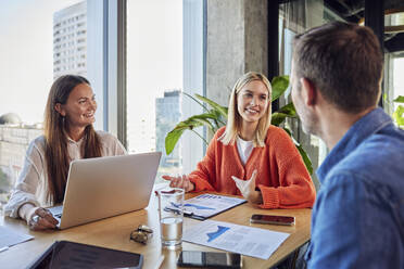 Smiling businessman and businesswomen having discussion in office - BSZF02422