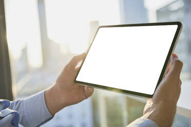 Hands of businessman holding tablet PC with blank screen - BSZF02612