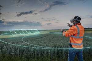 Engineer wearing VR glasses and operating digital solar panels in field - UUF31004