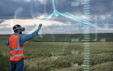 Wartungsingenieur, der eine digitale Windturbine durch eine VR-Brille im Feld bedient - UUF31010