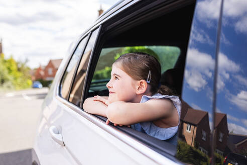 Excited girl looking through car window - WPEF08169