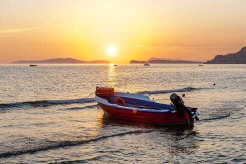 Griechenland, Ionische Inseln, Arillas, Motorboot links am Strand bei Sonnenuntergang - EGBF01041