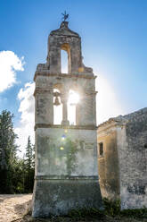Greece, Ionian Islands, Karousades, Sun shining through arches of old stone bells - EGBF01047