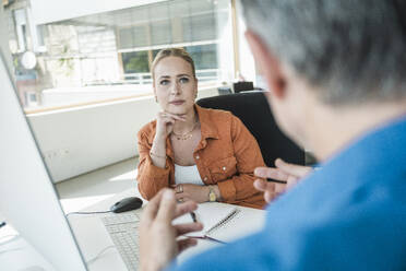 Geschäftskollegen bei einer Diskussion im Büro - UUF31034