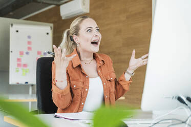 Überrascht Geschäftsfrau sprechen auf Video-Anruf durch Computer im Büro - UUF31045