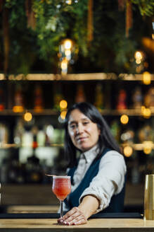 Bartender serving cocktail on bar counter - DAMF01271