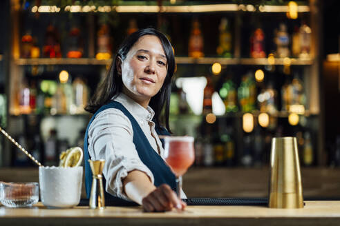 Bartender serving cocktail at bar counter - DAMF01272