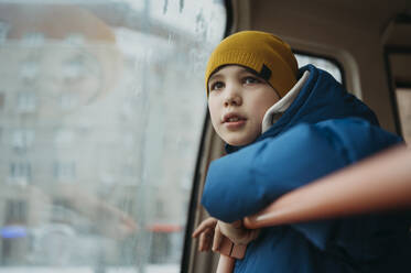 Boy traveling in bus and looking through window - ANAF02657