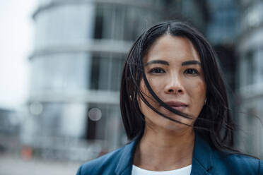 Smiling businesswoman in front of building - JOSEF23101