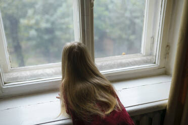Mädchen (4-5) schaut neugierig durch das Fenster - TETF02446