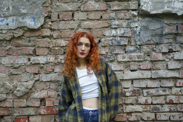 Redhaired woman posing next to old brick house - TETF02452