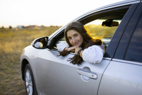 Porträt einer jungen Frau, die durch ein Autofenster schaut - TETF02529