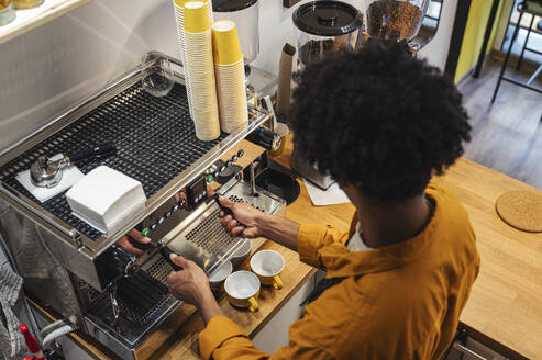 Barista operating coffee machine at cafe - ALKF00942