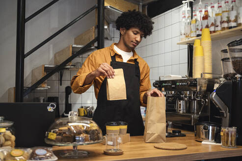 Barista packt Paket zum Mitnehmen im Coffeeshop - ALKF00950