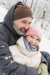 Glücklicher Vater und Tochter haben Spaß im Winterwald - EYAF02913
