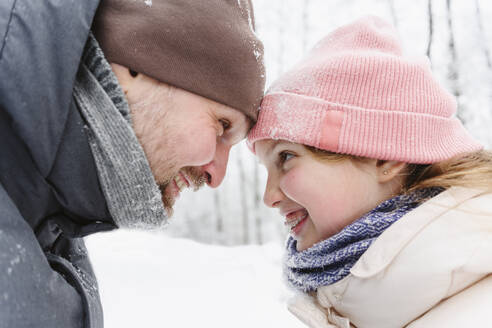 Playful father and daughter having fun in winter forest - EYAF02914