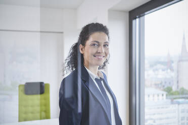 Happy mature businesswoman seen through glass - RORF03710