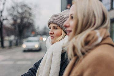 Friends wearing warm clothing at street - VSNF01579