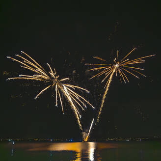 Italy, Veneto, Fireworks exploding over lake Garda at night - MHF00755