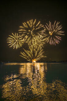 Italy, Veneto, Fireworks exploding over lake Garda at night - MHF00756