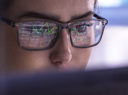 Geschäftsfrau mit Brille bei der Analyse von Finanzmarktdaten am Computer - ABRF01121