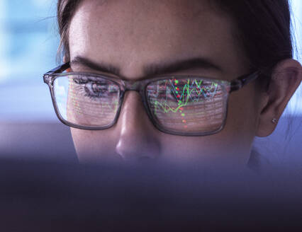 Young businesswoman examining financial market data on computer - ABRF01123