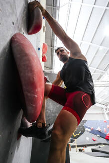 Sportler beim Bouldern an einer künstlichen Kletterwand - PBTF00396