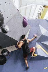 Sportler beim Bouldern an der künstlichen Wand in der Turnhalle - PBTF00400