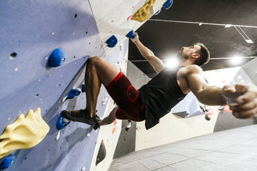 Sportler beim Klettern an der Boulderwand in der Sporthalle - PBTF00403