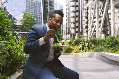 Businessman having salad at office park - OIPF03819