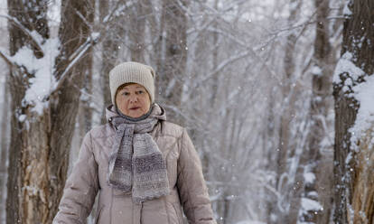 Ältere Frau trägt warme Kleidung im Park im Winter - MBLF00244