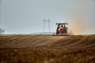 Landwirt im Traktor beim Kultivieren und Pflügen eines Feldes - NOF00911